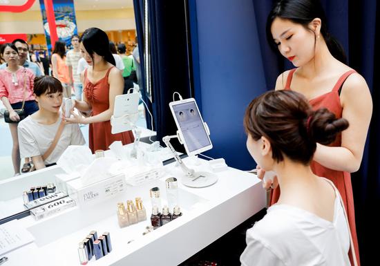 A customer tests cosmetic products at a Tmall pop-up store in Tianjin. In recent years, the majority of international makeup brands' sales have come from Chinese e-commerce websites such as Tmall and JD. （Photo by Niu Jing/For China Daily）