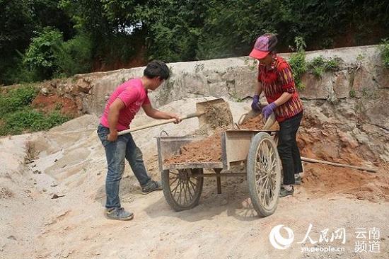 Cui Yuqing works at a construction site with his mother, July 22, 2018. (Photo/people.cn)