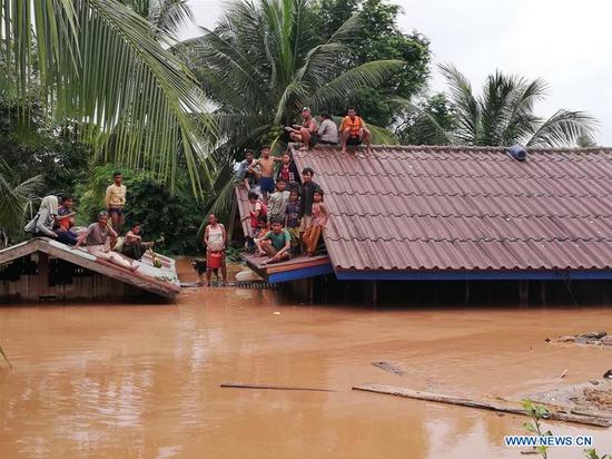 Villagers are seen stranded on rooftops of houses after an under-construction dam collapsed in Attapeu, Laos, on July 24, 2018. (Xinhua/Vilaphon Phommasane)