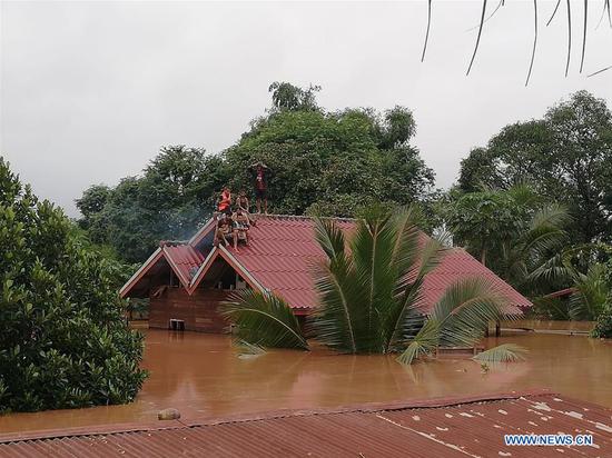 Villagers are seen stranded on rooftops of houses after an under-construction dam collapsed in Attapeu, Laos, on July 24, 2018. (Xinhua/Vilaphon Phommasane)