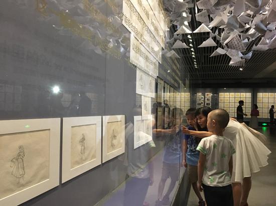 Visitors in front of the original scripts of the animation film Sleeping Beauty.(Photo: China Daily/Wang Kaihao)