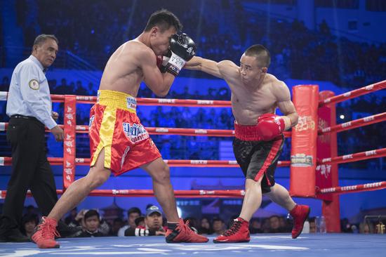 China's Xiong Chaozhong pounds Panya Pradabsri with a right hook en route to winning the WBC International minimumweight title last October in Datong, Shanxi province. （Photo: China News Service/Wei Liang）