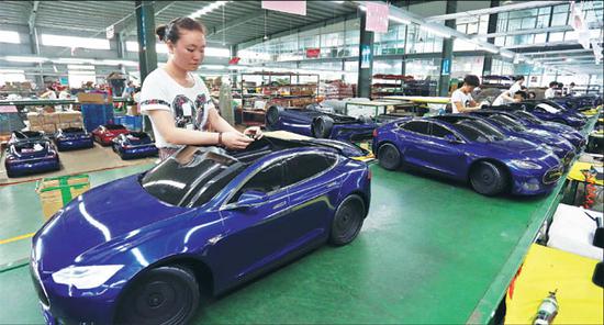 Workers assemble toy cars on a production line in a factory in Jinjiang, Fujian Province. (Photo provided to China Daily)
