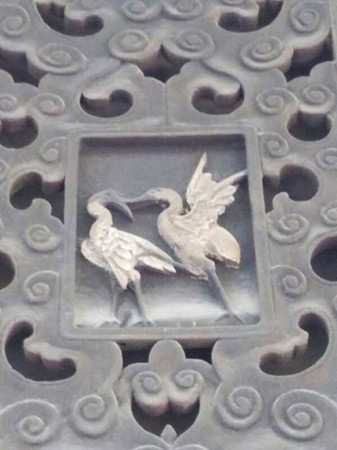 Two kissing cranes on a window bar. On the 24 window bars of the main hall of the more than 200-year-old Ancestral Hall of the Zhang Family in Lizhuang town in Yibin, Sichuan Province, are 48 carved cranes. There are two cranes on each window bar. (Photo by Huang Zhiling/China Daily)