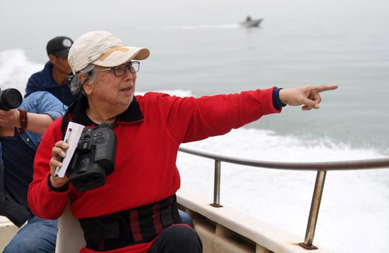 Chinese biologist Pan Wenshi investigates white dolphin activities in Sanniang Bay. (PHOTO/XINHUA)