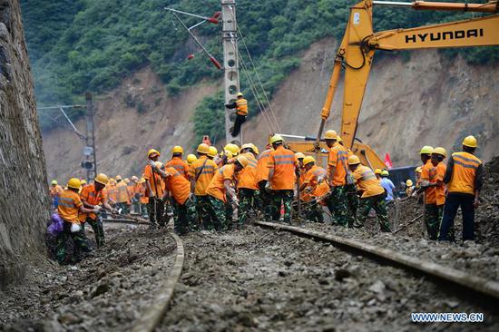 Rescuers work at the accident site in a section of the Baoji-Chengdu railway caused by rain-triggered landslides in Lueyang County, northwest China's Shaanxi Province, July 28, 2018. After 16 days' of arduous efforts, the blocked section of the Baoji-Chengdu railway in Shaanxi Province following several rain-triggered landslides was repaired and reopened to traffic by 5:00 p.m. Saturday. (Xinhua/Tang Zhenjiang)