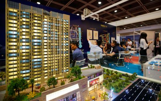A model of a property in Zhongshan, Guangdong province, at an expo in Hong Kong, attracts attention of prospective investors in June. (Photo/China News Services)