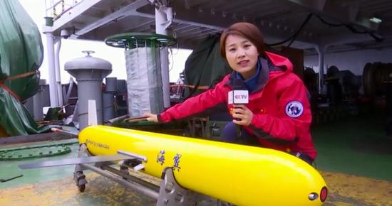 CCTV's reporter explains different parts of the underwater glider at a close range. (CCTV Photo)