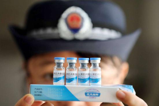 A law enforcement officer inspects vaccines at the Center for Disease Control and Prevention in Rong'an county of Liuzhou city in the Guangxi Zhuang autonomous region. (Photo by Tan Kaixing/China Daily)