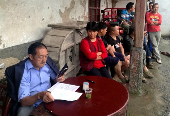 Qin Yuanfeng explains poverty relief policies to villagers in Xiping, Hubei Province, in May last year. (Photo/CHINA DAILY)