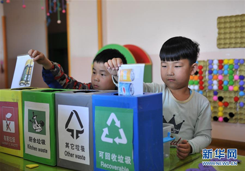 Children in Xiangyang Kindergarten play a game teaching them how to sort trash, Changzhi county, Shanxi Province, May 25, 2018. (Photo/Xinhua)