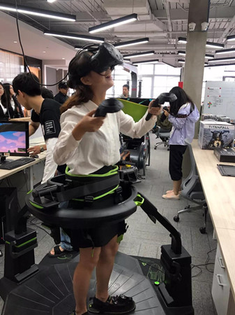 Hong Kong college students try out high-tech equipment during a visit to e-sports company Versus Programming Network in Shanghai. (Photo provided to China Daily)