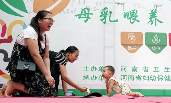 Mothers coax their babies to the finish line during a World Breast-Feeding Week activity held by the Henan Health and Family Planning Commission. (Photo by MA JIAN/FOR CHINA DAILY)