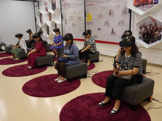 Residents from Beijing are experiencing VR technologies developed by Beijing Noitom Technology Ltd on July 31. （Photo provided to chinadaily.com.cn）