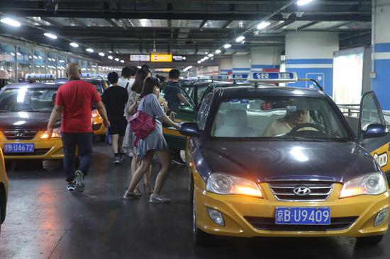Hailing a taxi is one of the difficulties at Beijing South, particularly late at night. (WANG JING/CHINA DAILY)
