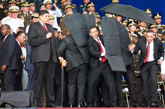 Security members protect Venezuelan President Nicolas Maduro after his speech was interrupted in Caracas, Venezuela, on Aug. 4, 2018. A speech by Venezuelan President Nicolas Maduro commemorating the 81st anniversary of the Bolivian National Guard was unexpectedly cut short after he was interrupted on Saturday. (Xinhua)