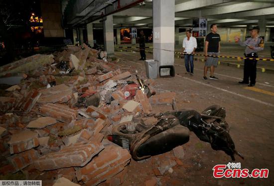 A policeman examines debris that fell and crushed parked motorbikes following a strong earthquake on nearby Lombok island, at a shopping center in Kuta, Bali, Indonesia August 5, 2018. (Photo/Agencies)