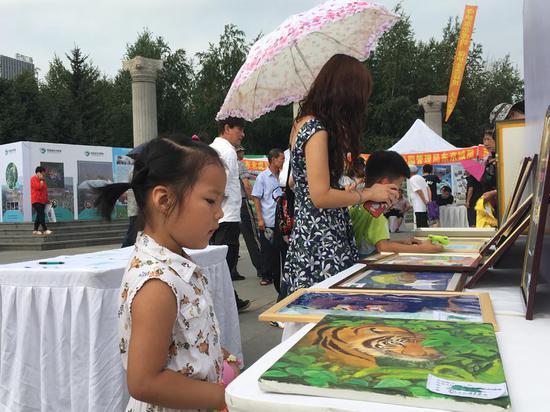 An art exhibition promoting wild tiger protection is held in a park in Changchun, Jilin Province. (Photo by Wang Kaihao/China Daily)