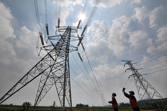 State Grid engineers inspect a power distribution tower in Zaozhuang, Shandong Province. (Photo provided to China Daily)