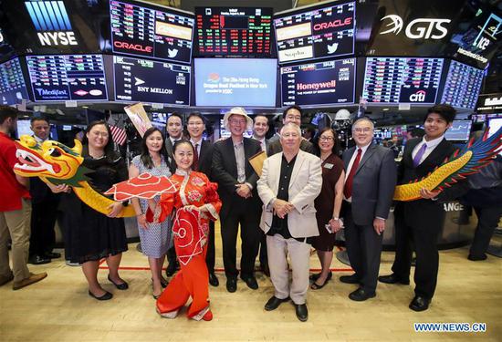 Performers and invited guests pose for a photo on the trading floor after ringing the opening bell at the New York Stock Exchange in New York, the United States, Aug. 6, 2018.  (Xinhua/Wang Ying)
