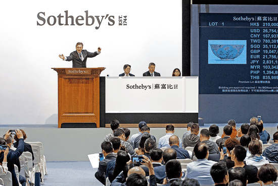 Henry Howard-Sneyd, Sotheby's chairman of Asian Art, Europe and Americas, fields bids in Hong Kong in April. (Photo/China Daily)