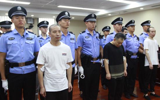 Zhang Wuya (left) and five accomplices stand trial at Haidian District People's Court in Beijing on Tuesday for using high-tech equipment to provide answers to 33 students during the national exam for graduate schools. (Photo provided to China Daily)