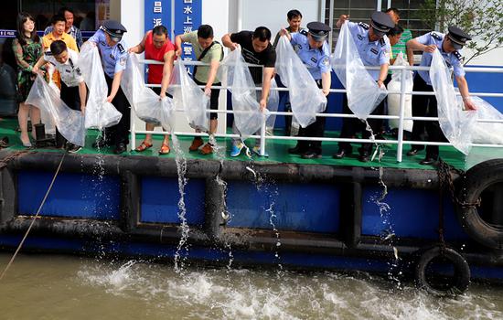 Police officers releases fish fries into a section of the Yangtze River in Wuhan, Hubei province, May 15, 2018.   (Photo/China Daily)
