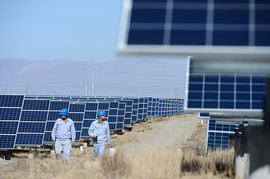 Technicians inspect solar power facilities in Gonghe county, Hainan Tibetan autonomous prefecture, Qinghai Province. (Photo/Xinhua)
