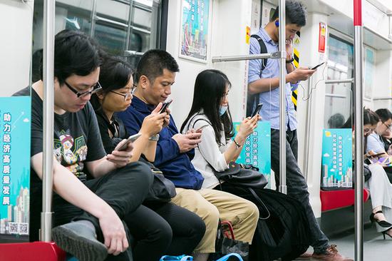 Passengers use mobile phones on the subway in Guangzhou, capital of Guangdong Province. (Photo provided to China Daily)