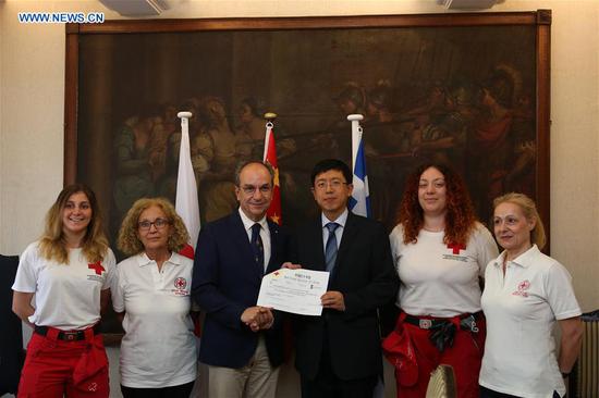 President of Greek Red Cross Nikolaos Oikonomopoulos (3rd L) receives donation from the charge d'affaires of the Chinese Embassy in Athens Wang Qiang (3rd R), on behalf of the Chinese Red Cross, to help Greece's wildfire victims, in Athens, Greece, on Aug. 9, 2018. The Red Cross Society of China on Thursday donated 100,000 U.S. dollars to the Greek Red Cross to support relief efforts for fire-stricken Greeks. (Xinhua/Marios Lolos)