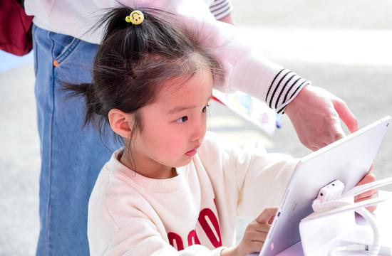 A girl tries the latest livestreaming courses of Xueersi Online School in Beijing. (Photo provided to China Daily)