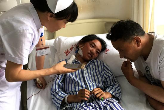 A nurse uses a mobile phone to translate and communicate with a Tibetan girl and her father at Zhengzhou Cardiovascular Hospital in Henan province on Thursday. (QI XIN/CHINA DAILY)