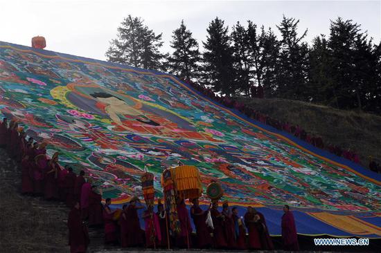 Lamas of Labrang Monastery attend a display ritual of a huge thangka painting of the Buddha in Xiahe County, northwest China's Gansu Province, Feb. 28, 2018.  (File photo: Xinhua/Fan Peishen)