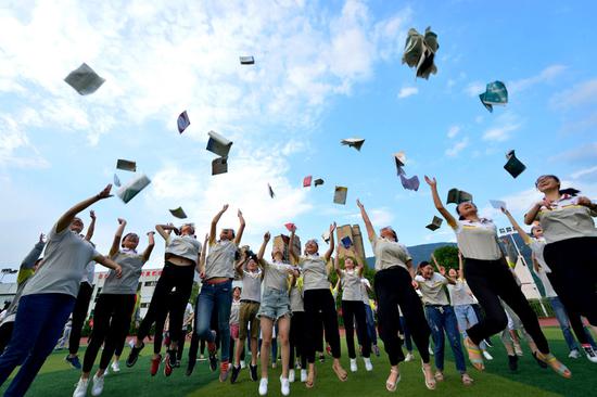 Students from Baokang county, Hubei Province, throw books into the air to celebrate the end of the gaokao exam in June. (Photo provided to China Daily)