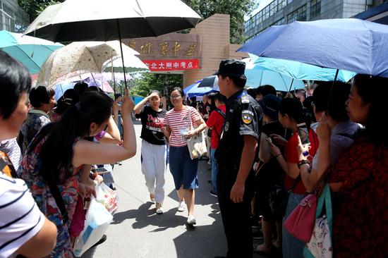 Parents welcome children who have completed the exam at the Affiliated School of Peking University in Beijing. (Wang Jing/China Daily)