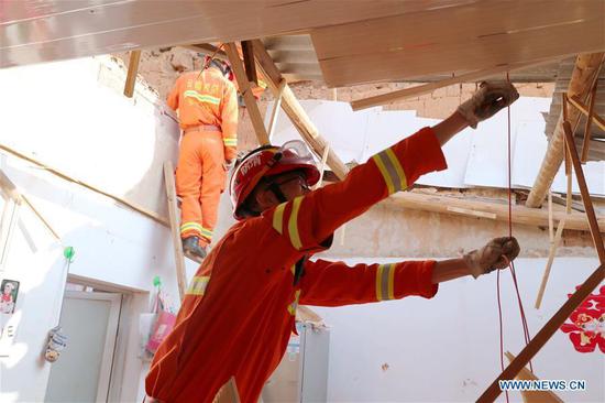 A rescuer works at a damaged house in Tonghai County, southwest China's Yunnan Province, Aug. 13, 2018. (Xinhua/Wang Anhaowei)