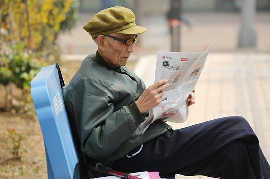 Zhou Zhifu, the late army officer, reads a newspaper in a garden at the sanatorium where he spent his post-retirement life. (Photo provided to China Daily)
