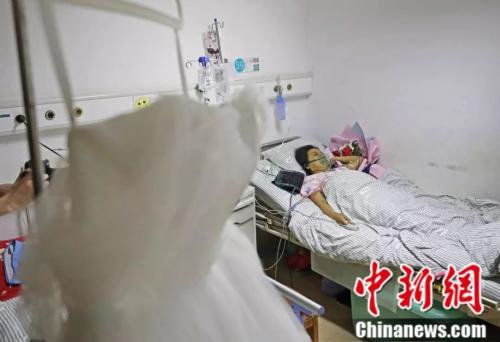 Xiaohui's wedding gown hangs in her hospital ward. 