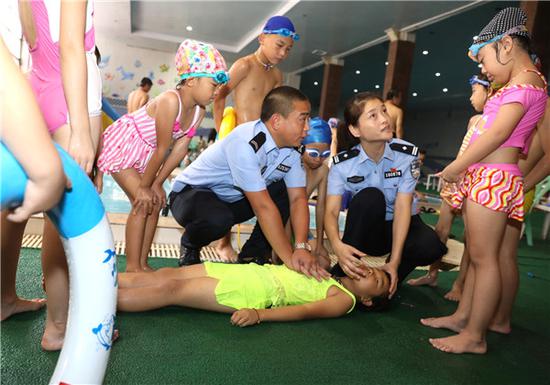Police officers teach children how to resuscitate a drowning person in Zhengzhou, Henan Province. (LIU SHUTING/FOR CHINA DAILY)