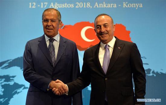 Turkish Foreign Minister Mevlut Cavusoglu (R) shakes hands with Russian Foreign Minister Sergey Lavrov during a press conference in Ankara, Turkey, on Aug. 14, 2018. Turkey and Russia will take steps to 