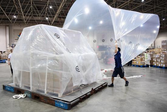 An employee prepares an air mail cargo shipment at the airport in Shenzhen. (Photo provided to China Daily)
