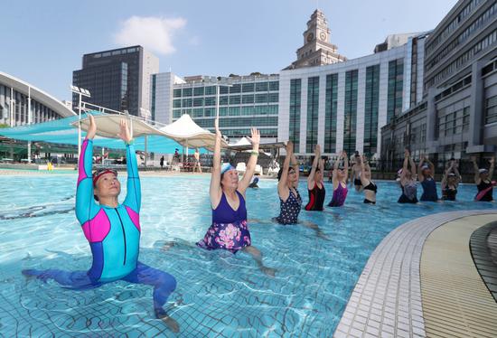 Retirees practice yoga in a swimming pool at a gym in Hangzhou, Zhejiang Province. (Photo by Lin Yunlong / For China Daily)