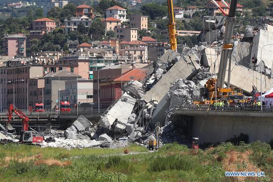 Heavy machines work at the site of the collapsed bridge in Genoa, Italy, Aug. 15, 2018. The region of Liguria surrounding the Italian northwest city of Genoa has officially filed a state of emergency request, after the dramatic collapse of a major bridge on Tuesday that caused so far 39 victims, the regional governor said on Wednesday.(Xinhua/Zheng Huansong)