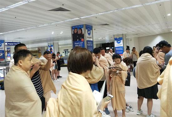 Photo taken on Aug. 17, 2018 shows passengers waiting at the Manila international airport after the plane crash-landed, in Manila, the Philippines. A Boeing 737-800 passenger plane of China's Xiamen Airlines landed on its belly early Friday at the Manila international airport, an airport official said. (Xinhua)