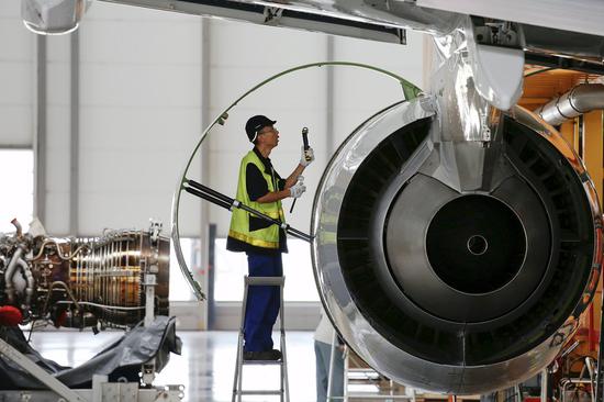 An employee checks an engine at the A320 family final assembly line of the Airbus factory in Tianjin. (Photo provided to China Daily)