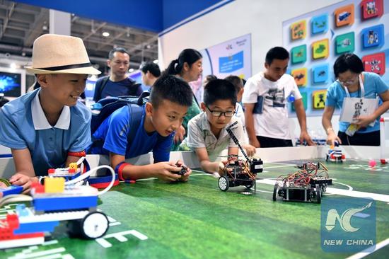 Children look at programming robots at World Robot Conference 2018 in Beijing, capital of China, Aug. 15, 2018.  (Photo: Xinhua/Li Xin)