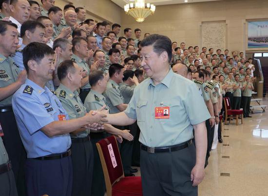 Xi Jinping, general secretary of the Communist Party of China Central Committee, president, and chairman of the Central Military Commission, greets delegates at a CMC meeting on Party building held from Friday to Sunday in Beijing. (LI GANG / XINHUA)
