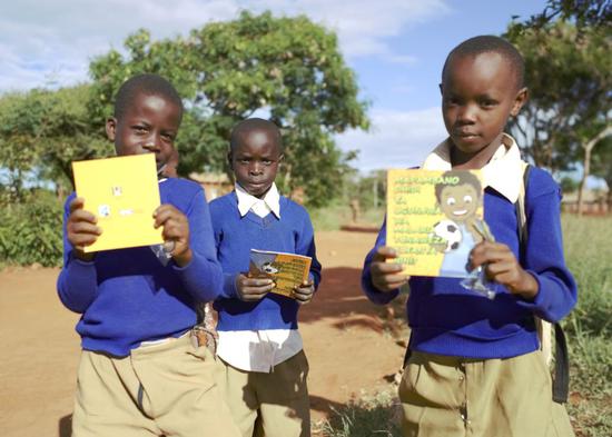 African children in Tanzania hold free anti-malaria brochures on the World Malaria Day on April 25. (Photo provided to China Daily)