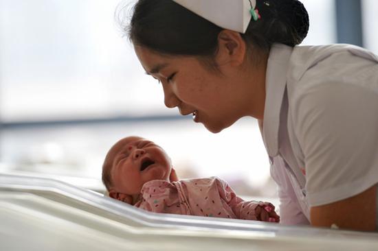 A nurse takes care of a newborn baby at Gansu Provincial Maternity and Childcare Hospital in Lanzhou. (Photo/Xinhua)