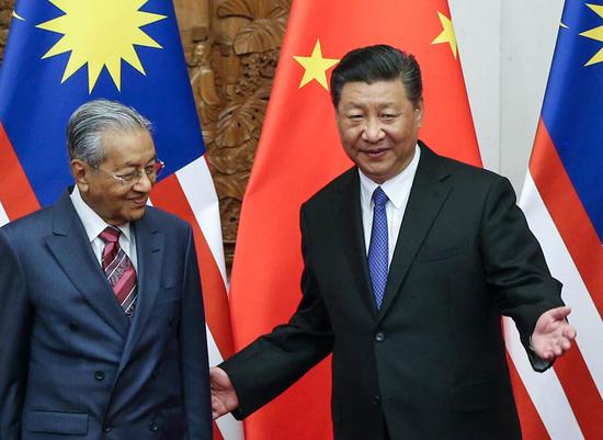 President Xi Jinping greets Malaysian Prime Minister Mahathir Mohamad at the Great Hall of the People in Beijing on Monday. During his talks with Mahathir, Xi said the two countries should be dedicated to raising the representation of developing countries in global affairs. WU ZHIYI / CHINA DAILY